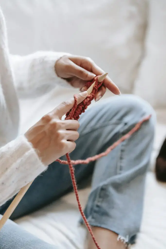 Easy cozy hobbies - woman knitting on white couch